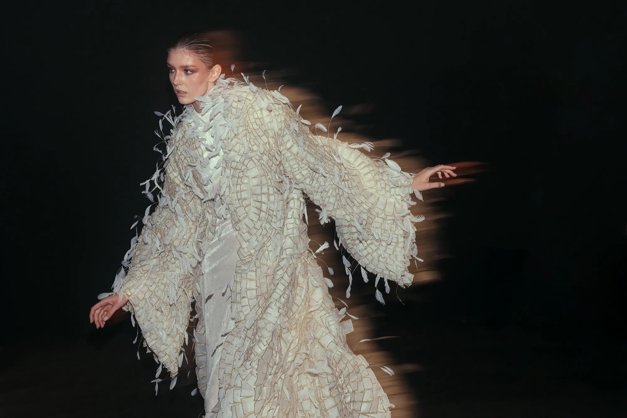 Mannequin en mouvement, en manteau couture à plumes