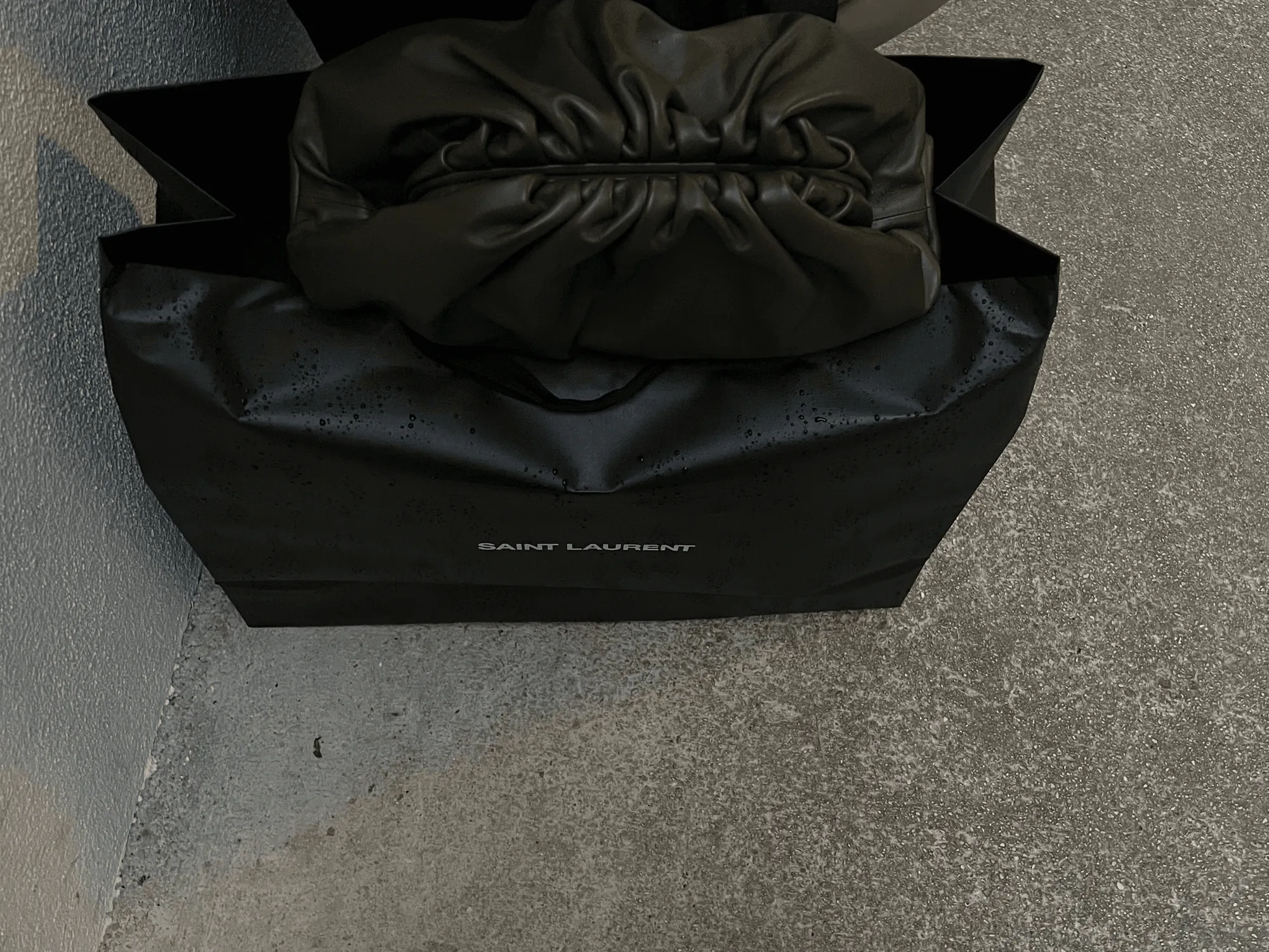 Un sac shopping noir posé sur le trottoir
